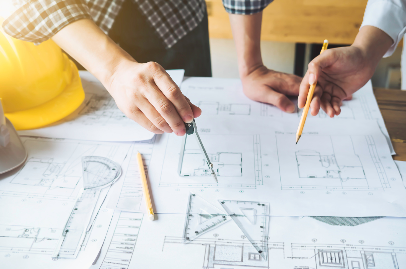 An image representing the design process with people working on blueprints